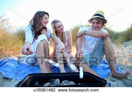 Friends having a beach BBQ View Large Photo Image Stock Image - Friends having a beach BBQ. Fotosearch
