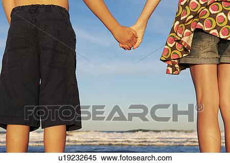 Girl and boy holding hands on the beach View Large Photo Image Stock Photography - Girl and boy holding hands on the beach. Fotosearch
