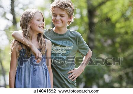 Stock Image - Girl and boy in garden. Fotosearch
