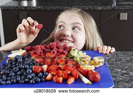 Stock Photo - Girl choosing some fruit. Fotosearch