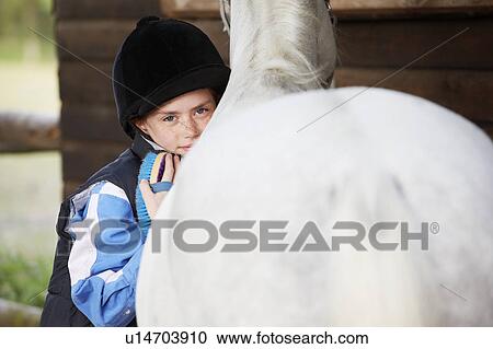 Stock Image - Girl cuddling her pony. Fotosearch