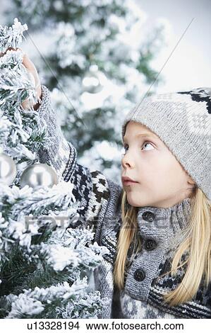 Picture - Girl decorating a christmas tree. Fotosearch