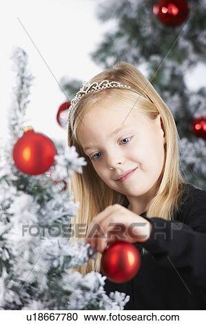 Girl decorating a christmas tree View Large Photo Image Stock Image - Girl decorating a christmas tree. Fotosearch