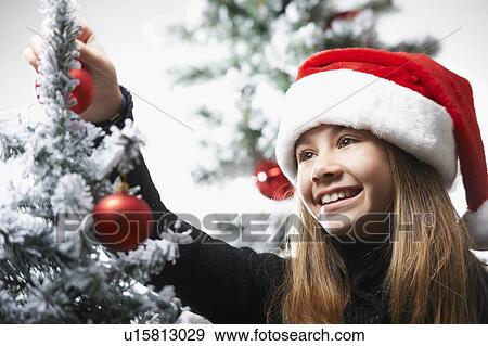 Girl decorating the christmas tree View Large Photo Image Stock Photo - Girl decorating the christmas tree. Fotosearch