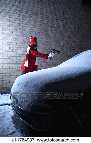 Stock Photo - Girl defrosting car with hair drier. Fotosearch