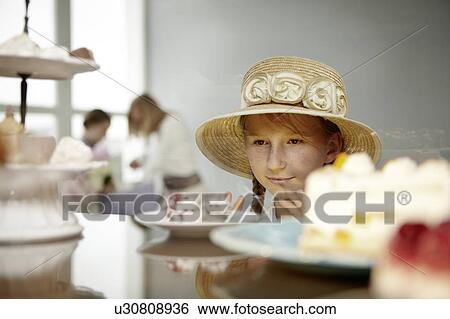 Stock Photograph - Girl eyeing cake. Fotosearch