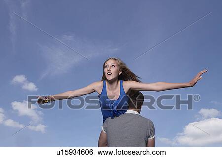 Stock Photograph - Girl flying on boys shoulders. Fotosearch
