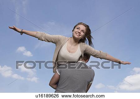 Girl flying on boys shoulders View Large Photo Image Stock Photograph - Girl flying on boys shoulders. Fotosearch