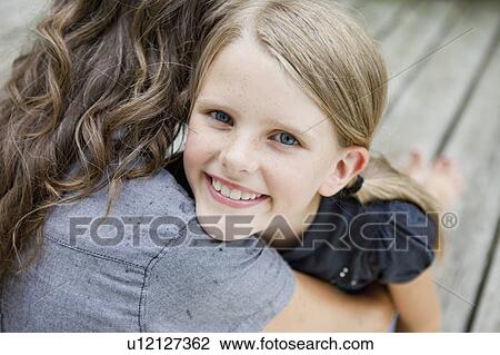 Girl happily hugging her mother View Large Photo Image Stock Image - Girl happily hugging her mother. Fotosearch