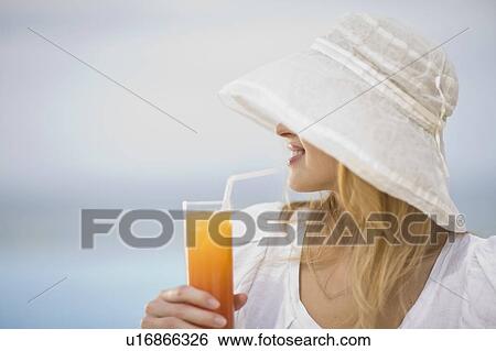 Girl having a drink View Large Photo Image Stock Photograph - Girl having a drink. Fotosearch