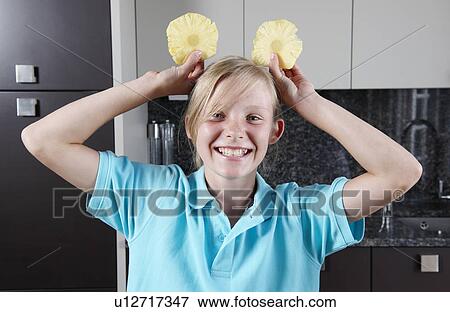 Stock Photo - Girl holding pineapple slices. Fotosearch