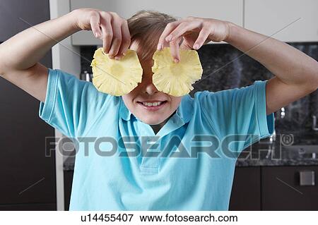 Stock Photo - Girl holding pineapple slices. Fotosearch