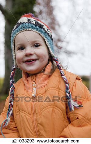 Girl in knitted cap and orange jacket View Large Photo Image Stock Image - Girl in knitted cap and orange jacket. Fotosearch
