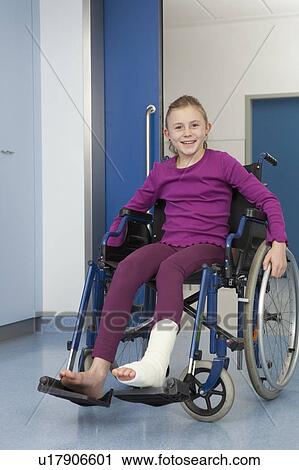 Stock Image - Girl in wheelchair, foot in plaster. Fotosearch