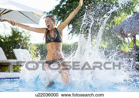 Girl jumping into swimming pool View Large Photo Image Stock Image - Girl jumping into swimming pool. Fotosearch