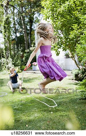 Girl jumping rope in garden View Large Photo Image Stock Image - Girl jumping rope in garden. Fotosearch