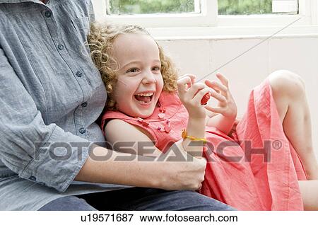 Girl laughing in Mum's arms View Large Photo Image Stock Photo - Girl laughing in Mum's arms. Fotosearch