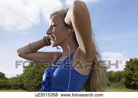Stock Photo - Girl listening to headphones. Fotosearch
