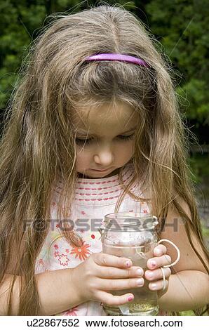 Girl looking at fish caught in jam jar View Large Photo Image Stock Image - Girl looking at fish caught in jam jar. Fotosearch