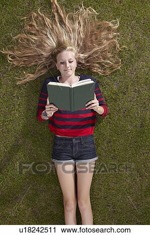 Girl lying reading a book View Large Photo Image Stock Image - Girl lying reading a book. Fotosearch