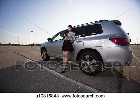 Girl on phone by car View Large Photo Image Stock Image - Girl on phone by car. Fotosearch