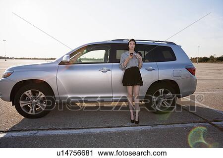 Girl on phone by car View Large Photo Image Stock Image - Girl on phone by car. Fotosearch