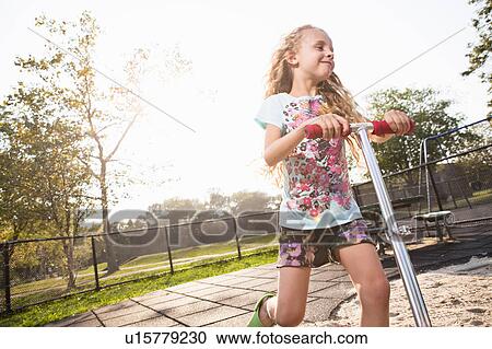Girl on scooter View Large Photo Image Stock Image - Girl on scooter. Fotosearch