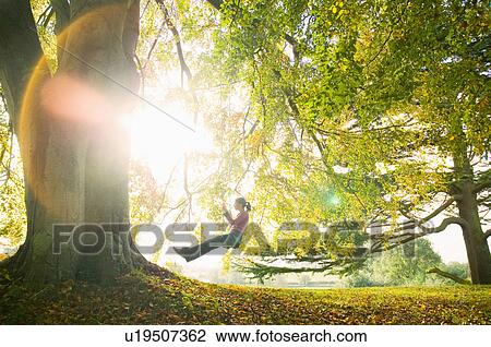 Girl on swing in sun View Large Photo Image Stock Image - Girl on swing in sun. Fotosearch