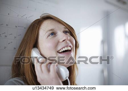 Stock Photo - Girl on telephone leaning on calendar. Fotosearch