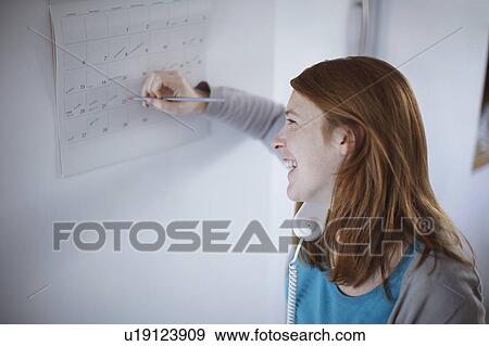 Girl on telephone writing on calendar View Large Photo Image Stock Photo - Girl on telephone writing on calendar. Fotosearch