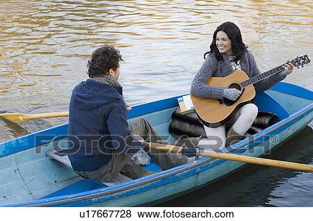 Girl playing guitar in row boat View Large Photo Image Stock Photo - Girl playing guitar in row boat. Fotosearch