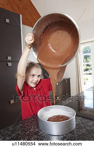 Picture - Girl pouring cake mix into cake tin. Fotosearch