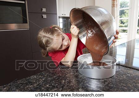 Picture - Girl pouring cake mix into cake tin. Fotosearch
