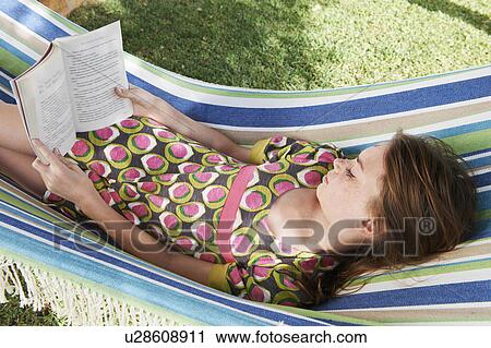 Girl reading a book in a hammock View Large Photo Image Stock Image - Girl reading a book in a hammock. Fotosearch