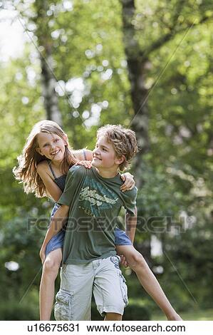 Girl riding on boy's back View Large Photo Image Stock Image - Girl riding on boy's back. Fotosearch