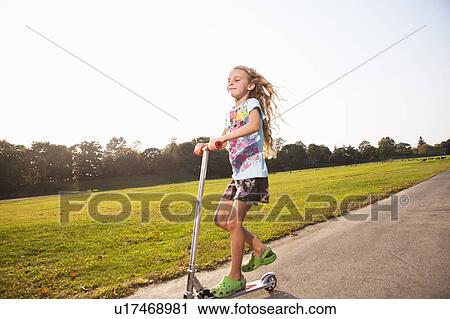 Girl riding scooter View Large Photo Image Stock Image - Girl riding scooter. Fotosearch