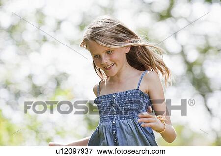 Girl running in garden View Large Photo Image Stock Photo - Girl running in garden. Fotosearch