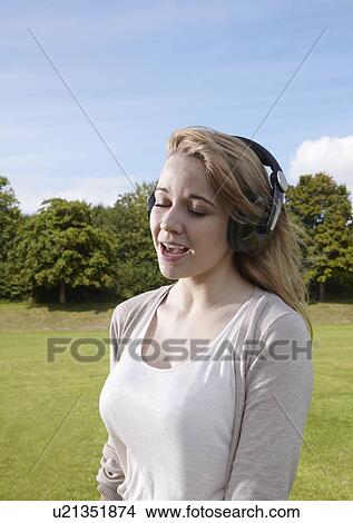 Girl singing along to headphones View Large Photo Image Picture - Girl singing along to headphones. Fotosearch