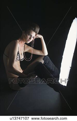 Girl sitting in front of light View Large Photo Image Stock Photo - Girl sitting in front of light. Fotosearch