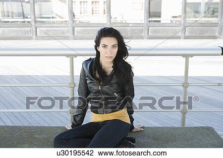 Stock Image - Girl sitting on boardwalk. Fotosearch