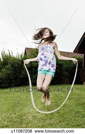 Girl skipping in garden View Large Photo Image Stock Photo - Girl skipping in garden. Fotosearch