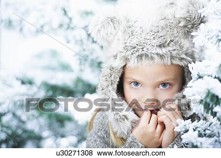 Stock Photo - Girl standing between snowy trees. Fotosearch