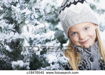 Stock Photography - Girl standing between snowy trees. Fotosearch