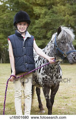 Stock Image - Girl standing with horse. Fotosearch