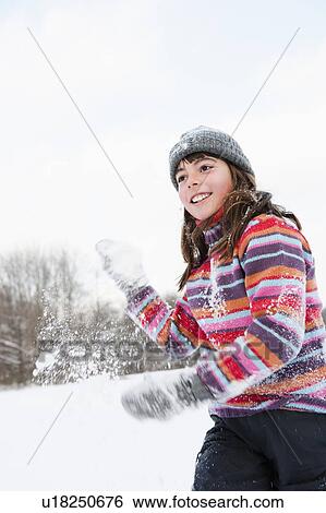 Girl throwing a hand full of snow View Large Photo Image Stock Photograph - Girl throwing a hand full of snow. Fotosearch