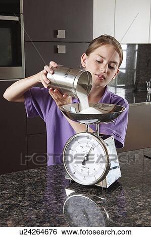Girl weighing sugar on kitchen scales View Large Photo Image Stock Photograph - Girl weighing sugar on kitchen scales. Fotosearch