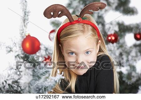 Stock Photo - Girl with a deer-headband by the tree. Fotosearch