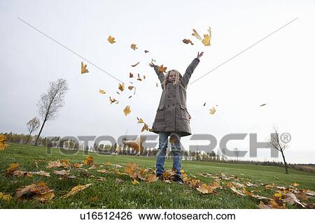 Stock Photograph - Girl with autumn leaves. Fotosearch