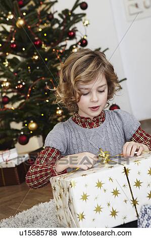 Stock Photo - Girl with big present in front of tree. Fotosearch