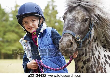Stock Image - Girl with her pony. Fotosearch